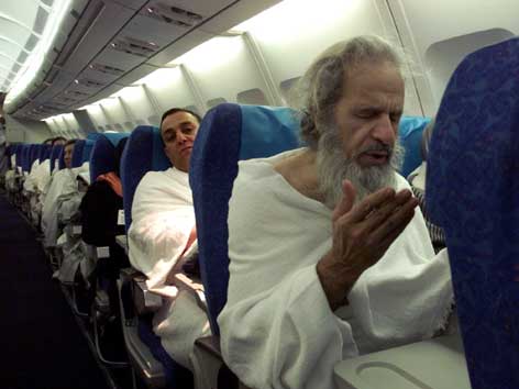 Muslime beten in einem Flugzeug.
